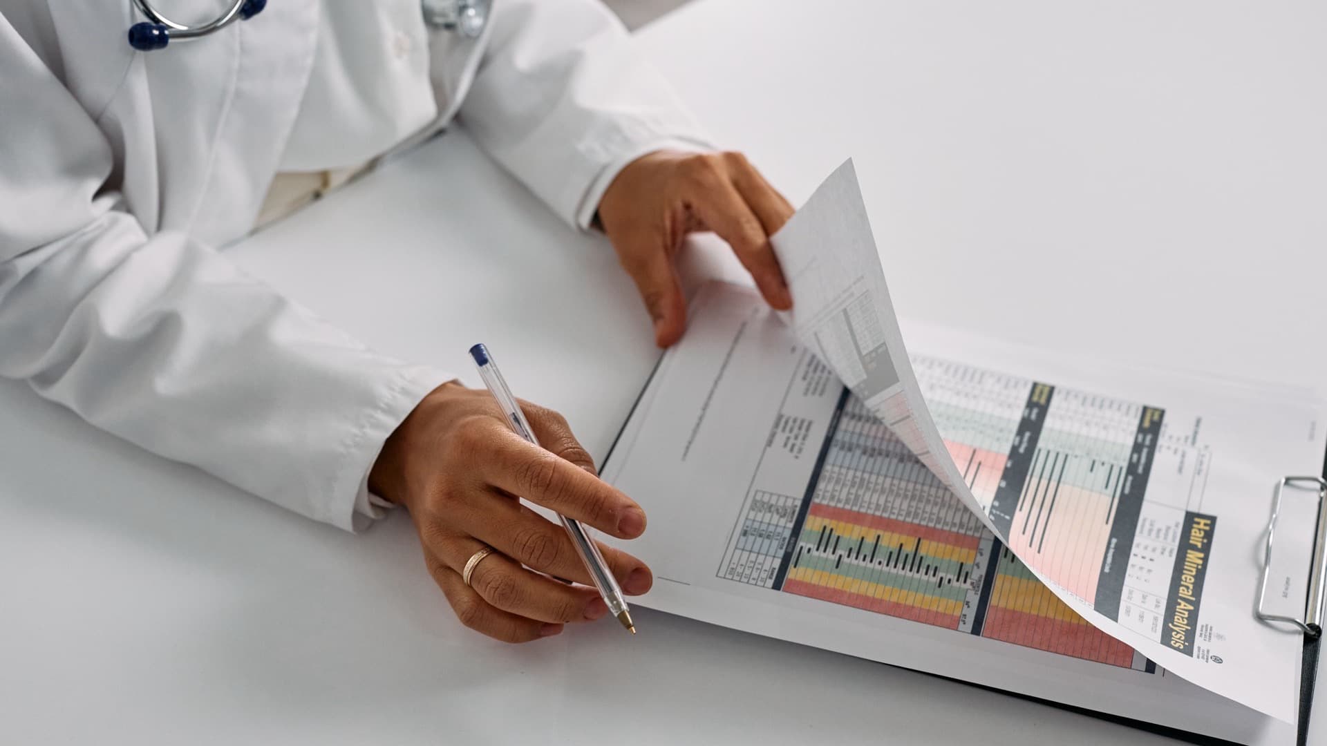 Medico revisando relatorios com graficos e indicadores sobre a mesa